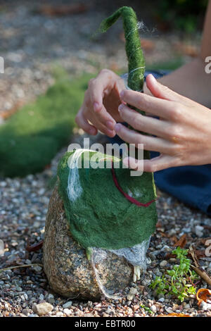 "Feltro stone troll' che serve come giardino decorazione: pietre naturali essendo dotato di cappelli di feltro imbevuto di lana, Germania Foto Stock