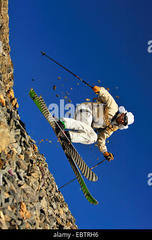 Sciatore freeride dissimulata come oldfashioned avventuriero in discesa sul pendio roccioso Foto Stock