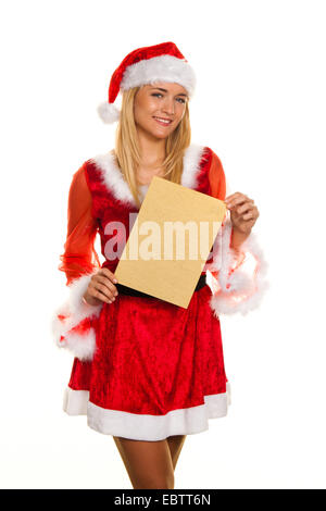 Giovane donna in un costume di Santa tenendo un foglio vuoto di carta per gli auguri natalizi Foto Stock