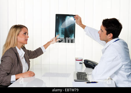 Il paziente e il medico guardando un X-ray fotografia Foto Stock