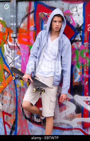 Bel giovane uomo davanti al muro di graffiti Foto Stock