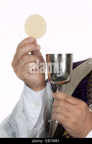 Sacerdote cattolico con un calice e host alla comunione Foto Stock