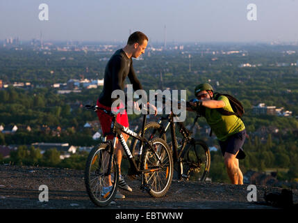 Due mountain biker sulla sommità di incetta di Haniel, in Germania, in Renania settentrionale-Vestfalia, Bottrop Foto Stock