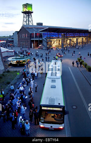 Persone presso il bus navetta a Jahrhunderthalle Bochum in serata, in Germania, in Renania settentrionale-Vestfalia, la zona della Ruhr, Bochum Foto Stock