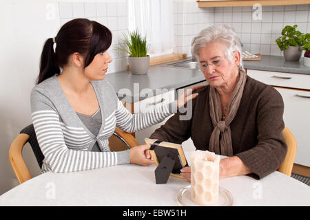 Giovane donna consolante di una vedova dopo il caso di morte, lutto counseling Foto Stock