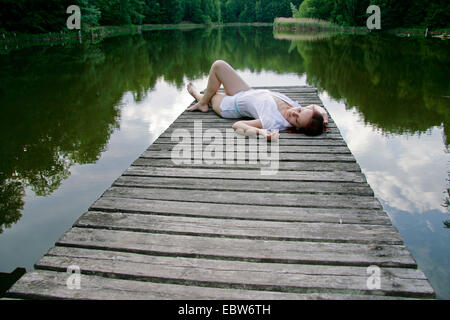 Giovane donna giacente sul Boardwalk, Germania, il Land Brandeburgo Foto Stock