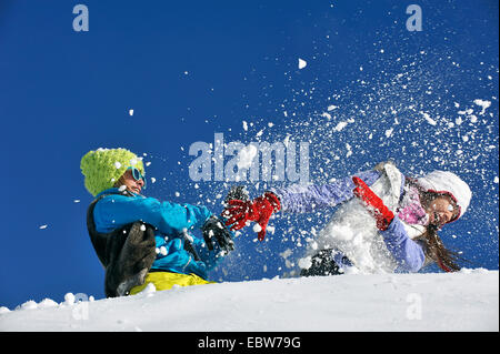 Due giovani ragazze frolicly combattimenti nella neve, Francia Foto Stock