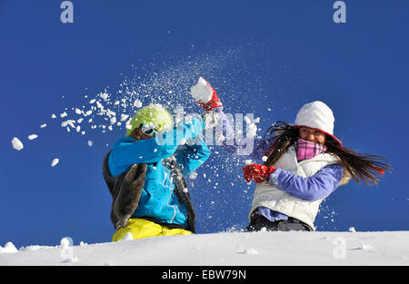 Due giovani ragazze frolicly combattimenti nella neve, Francia Foto Stock