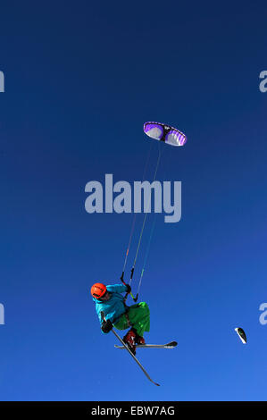 L'uomo galleggiante nella parte anteriore del cielo blu chiaro parapendio con gli sci, Francia Foto Stock