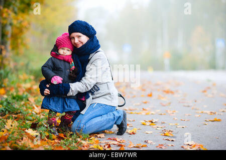 Giovane madre con la sua piccola figlia in autunno Foto Stock