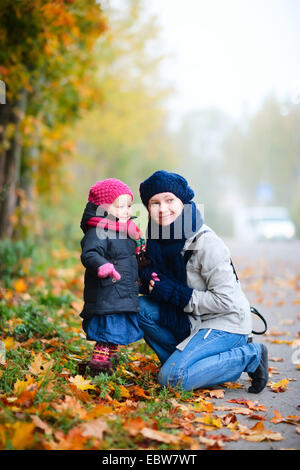 Giovane madre con la sua piccola figlia in autunno Foto Stock