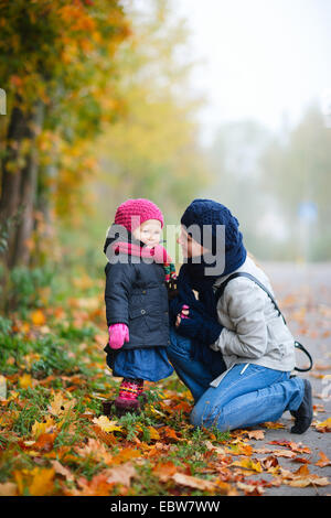 Giovane madre con la sua piccola figlia in autunno Foto Stock