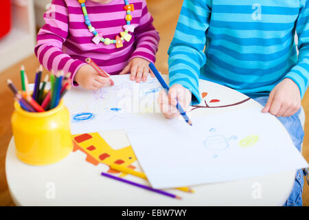 Due bambini piccoli di Disegno con matite colorate Foto Stock