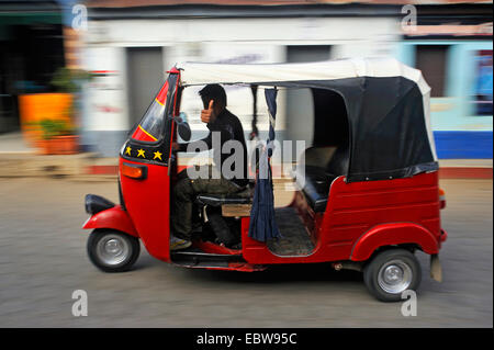 Taxi driver passando nella sua auto rickshaw che mostra il pollice rivolto verso l'alto, Guatemala, lago Atitlan, Santa cruz la Laguna Foto Stock