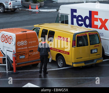 I furgoni appartenenti a TNT DHL e FedEx parcheggiato nel centro cittadino di Vancouver, Canada Foto Stock