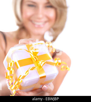 Messa a fuoco selettiva foto di un sorridenti azienda femmina in mani poco confezione regalo con nastro dorato, celebrazione di Natale Foto Stock