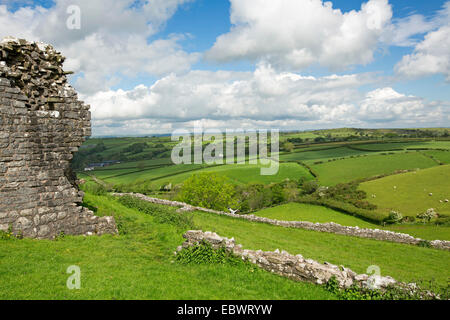 Vista spettacolare dalla Carrig Cennen Castle of Welsh terreni coltivati su verdi colline e valli, con antichi muri di pietra in primo piano Foto Stock