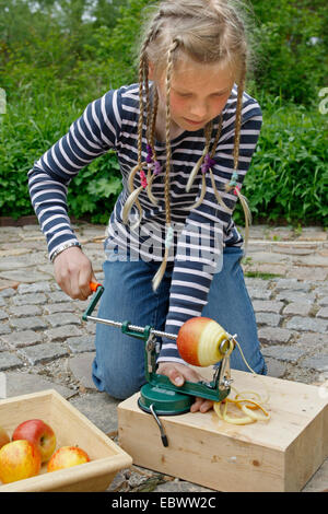 I bambini sono la realizzazione di un disidratatore apple; ragazza è sbucciare e tagliare una Apple utilizzando un Apple Macchina pelatrice, Germania Foto Stock