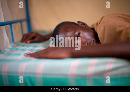 Ritratto di un giovane uomo disteso su un letto, Burundi Bujumbura Foto Stock