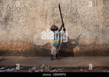 Little Boy a giocare con vecchi machete, Burundi Bujumbura Mairie, Bujumbura Foto Stock