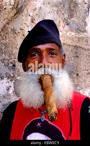 Uomo con barba folta e berretto di fumare un sigaro lungo, Cuba, La Habana Foto Stock