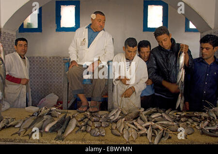 Gli uomini in una sala al mercato del pesce sulla isola di Djerba, Tunisia, Djerba Foto Stock