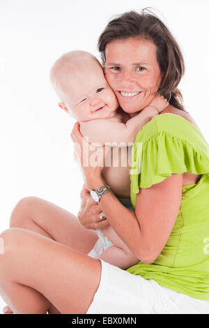 10 mesi di età bambino nelle braccia di sua madre Foto Stock