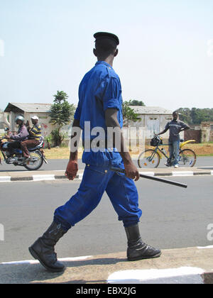 Funzionario di polizia con baton pattugliamento su una larga strada della capitale, Burundi Bujumbura marie, Rohero 1, Bujumbura Foto Stock