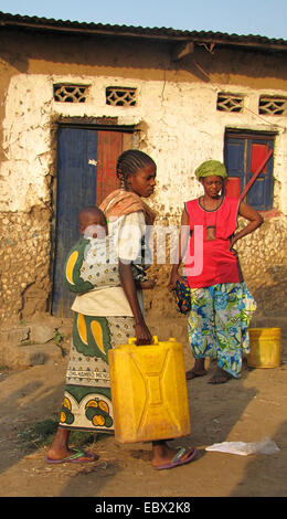 Donne presso la zona povera della città capitale prendendo l'acqua nelle loro case in canestri, bambino dorme sulla sua madre la schiena, Burundi Bujumbura mairie, Buyenzi Bujumbura Foto Stock