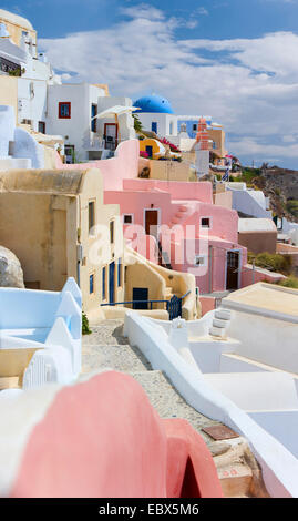 Panorama che si vede oltre le case colorate del villaggio presso la ripida costa dell'isola, Grecia CICLADI, Santorini, Oia Foto Stock