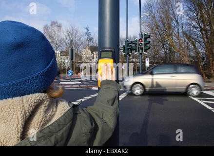 Bambino premendo il sensore di luce di pedone Foto Stock