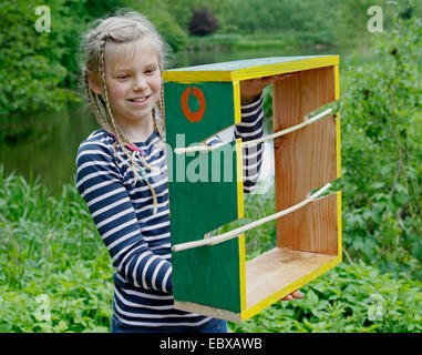 I bambini sono la realizzazione di un disidratatore apple; la ragazza con il finito e verniciato colorato apple essiccatore, Germania Foto Stock