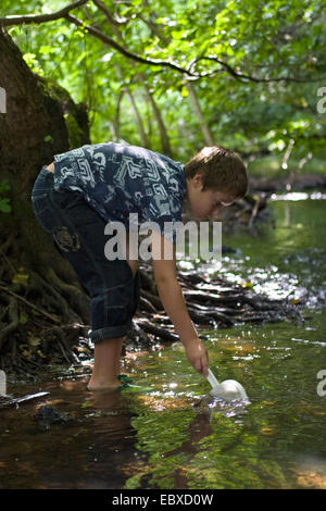 Ragazzo con dip-net in un torrente Foto Stock