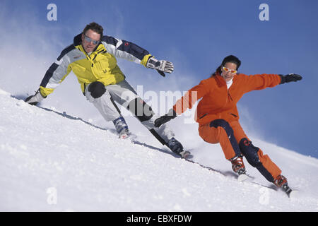Due con rifiniture senza bastoncini da sci a fianco a fianco in corsa Foto Stock