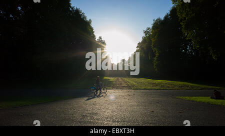 Un ciclista sul trasporto London bike in Kensington Park come set di sole Foto Stock
