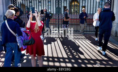 I membri del pubblico fuori Buckingham palace prendendo fotografie e selfies Foto Stock
