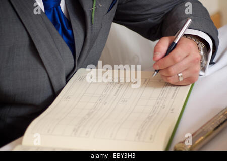 Sposa e lo sposo di firmare il registro di matrimonio Foto Stock