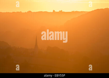 Painswick chiesa in Cotswolds all'alba in una nebbiosa mattina, Gloucestershire, Inghilterra. In autunno (settembre) 2014. Foto Stock