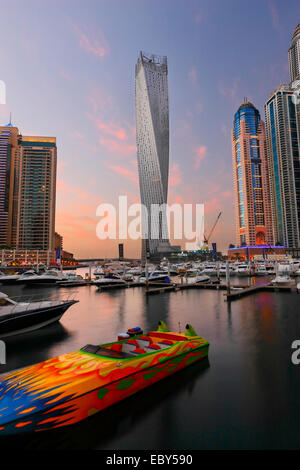 Marina di Dubai skyline. Barca veloce nella parte anteriore e twisted tower sul retro. Foto Stock