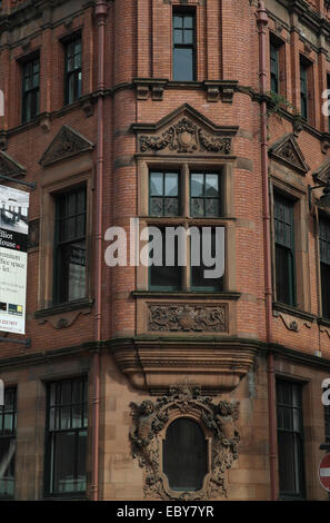 Ritratto Solare angolo rosso dei mattoni di pietra arenaria Eliot House con finestra ovale sculture cherubino, Deansgate al Jackson's Row, Manchester Foto Stock