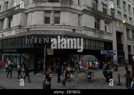 Pomeriggio di visualizzare molte persone a piedi passato marciapiede angolo di strada ingresso Debenhams, Market Street a Tib Street, Manchester, Regno Unito Foto Stock
