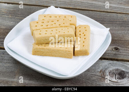 Chiudere l'immagine orizzontale di biscotti al burro sul tovagliolo bianco e la piastra con legno rustico al di sotto Foto Stock