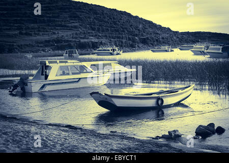 Imbarcazioni a remi e barche a motore lungo la riva del lago Titicaca in Challapampa su Isla del Sol in Bolivia Foto Stock