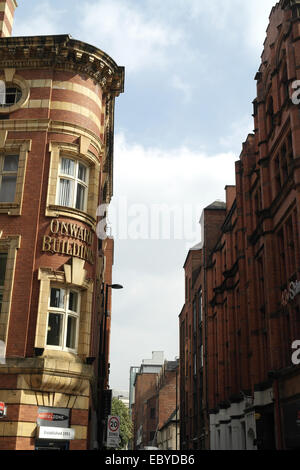 Ritratto Solare angolo curvo di mattoni rossi di arenaria gialla strisce Onward edifici, Deansgate a Bootle Street, Manchester, Regno Unito Foto Stock