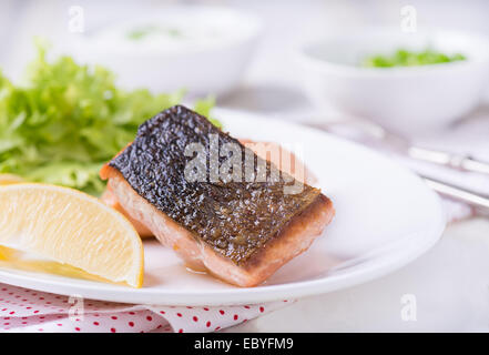 Grigliate di pesce rosso Filetto con limone e insalata verde, vicino il fuoco selettivo Foto Stock