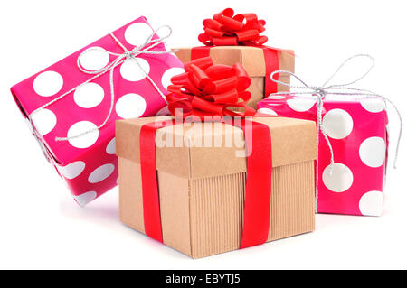 Una pila di confezioni regalo di diversi colori legati con differenti nastri su sfondo bianco Foto Stock