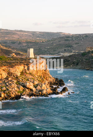 Ghajn Tuffieha Tower, un'antica torre di avvistamento e la rocca a Golden Bay Malta nel sole di setting Foto Stock