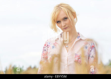 Bella donna bionda in posa nel campo di grano. Foto Stock