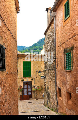 Strada stretta con pietre in ciottoli di Valldemossa, un piccolo villaggio nella regione di Tramuntana, Mallorca, Spagna Foto Stock