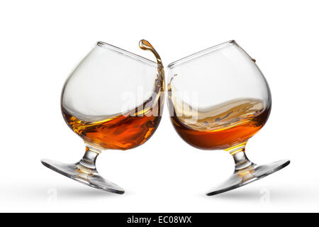 Spruzzata di cognac in due bicchieri isolati su sfondo bianco Foto Stock